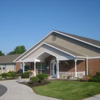 A residential building with a landscaped front yard and driveway.