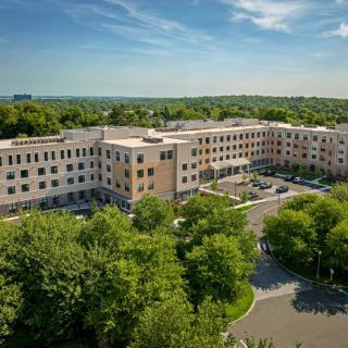 Aerial view of a large residential building surrounded by trees.