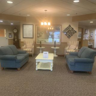 A cozy lobby area featuring sofas, chairs, and a central coffee table.
