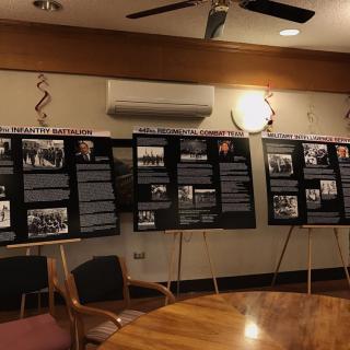 An indoor exhibition showcasing informational posters in a meeting room setting.