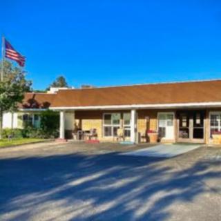 A single-story building with an American flag flying outside on a sunny day.
