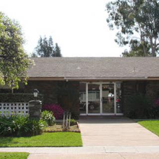 A charming residential house with well-maintained landscaping and a welcoming front yard.
