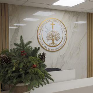 A serene office reception area featuring a decorative logo and potted plants.