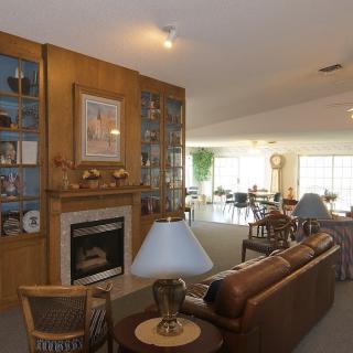 A cozy living room with a fireplace, sofa, and built-in shelves.