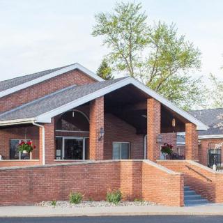 A modern brick building with a prominent entrance and sloped roof.