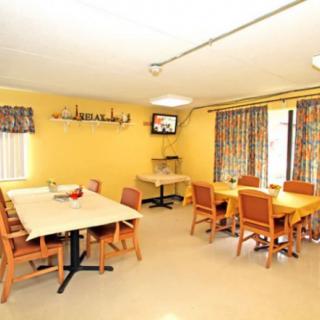 A cozy dining room with multiple tables and chairs arranged for communal meals.