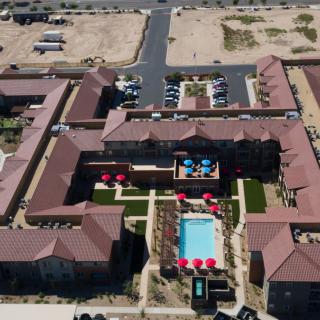 Aerial view of a residential complex with swimming pools and landscaped courtyards.