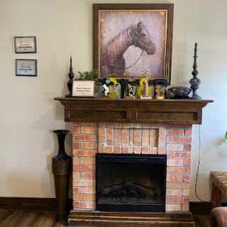 A charming fireplace mantel adorned with a horse portrait and decorative items.