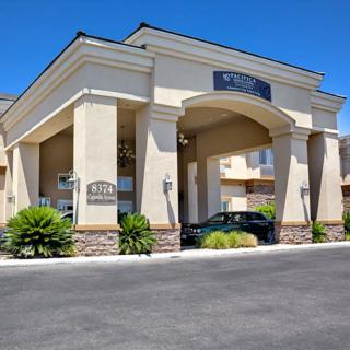 A hotel building with an elegant entrance and a parked car in front.