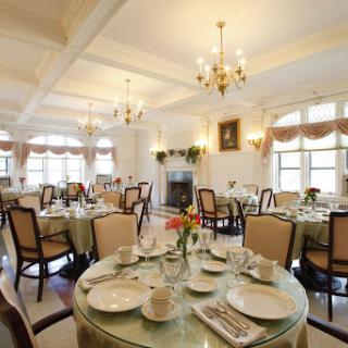 An elegant dining room set for a meal, featuring beautifully arranged tables and chandeliers.