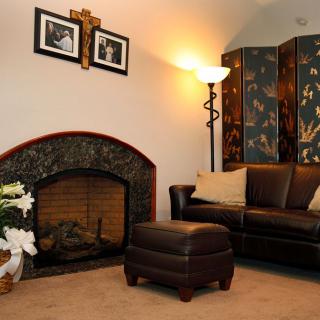 A cozy living room with a fireplace, leather couch, and decorative elements.