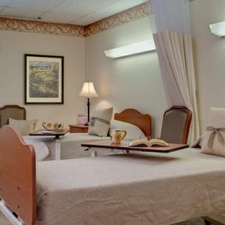 A hospital room with two beds and medical equipment.