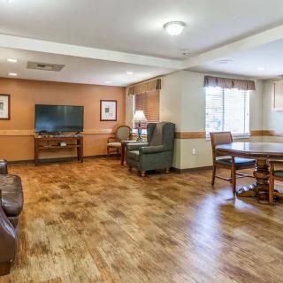 A cozy living room with wooden floors, a TV, and ample seating.
