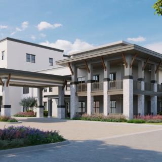 A modern residential building with large columns and landscaped surroundings.