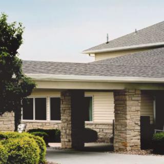 A suburban home with stone pillars and a neatly maintained exterior.