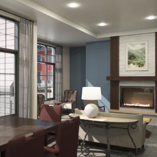 A cozy and stylish living room featuring a fireplace, comfortable seating, and large windows.