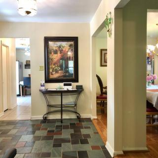 A well-decorated hallway featuring a framed artwork and tiled flooring.