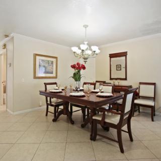 A well-lit dining room with a set table, a chandelier, and decorative artwork on the walls.