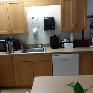A modern kitchen with wooden cabinets, a sink, and various appliances.