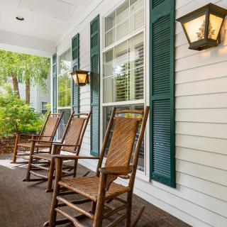 A charming porch with wooden rocking chairs and green shutters.