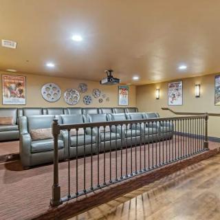A cozy home theater room with tiered seating and movie-themed decor.