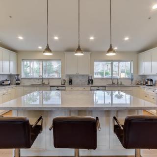 A spacious, modern kitchen with a large island and pendant lighting.