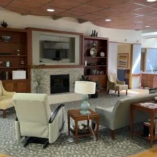 A cozy living room with comfortable seating, a fireplace, and bookshelves.