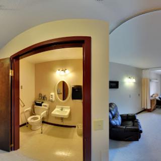 A view of a bathroom with modern amenities and adjoining living space.