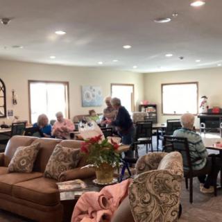 A group of elderly individuals socializing in a cozy living room setting.