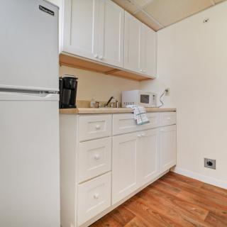 A compact kitchen with white cabinets and appliances.