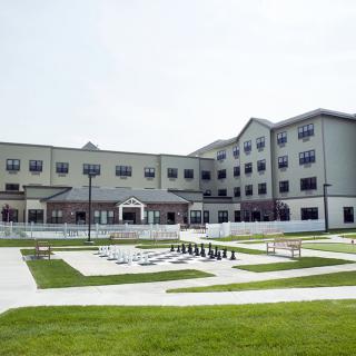 A modern building with a well-maintained green lawn and paved pathways.