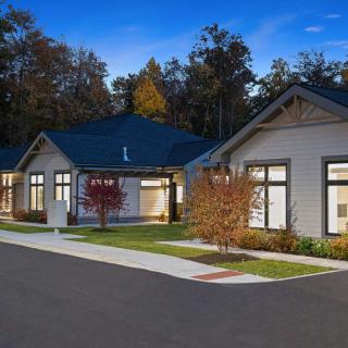 A modern suburban house in the evening with landscaped surroundings.