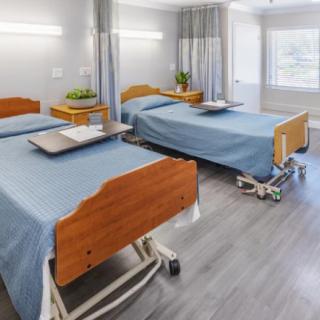 A clean and modern hospital room with two beds and medical equipment.