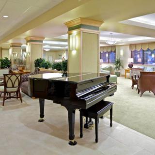 A luxurious lobby featuring a grand piano and elegant seating areas.