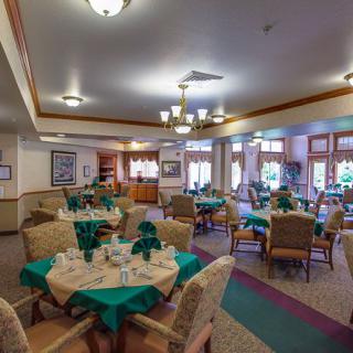 A spacious dining area with neatly arranged tables and chairs, featuring elegant interior decor and lighting.
