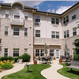 A residential building with an inviting courtyard featuring a garden and outdoor seating area.