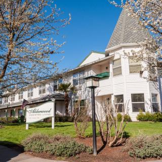 A charming residential building surrounded by trees on a sunny day.