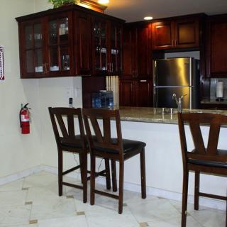 A modern kitchen with a breakfast bar and dark wooden cabinets.