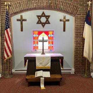 A multi-faith altar featuring Christian crosses and a Star of David, symbolizing interfaith dialogue.