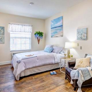 A cozy bedroom with artwork, a comfortable bed, and soft lighting.