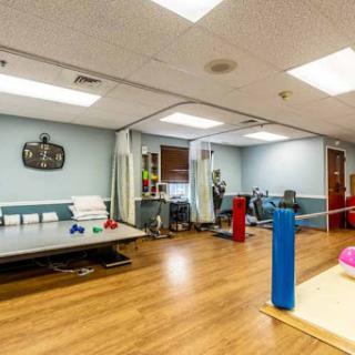 A spacious therapy room equipped with various fitness tools and a welcoming atmosphere.