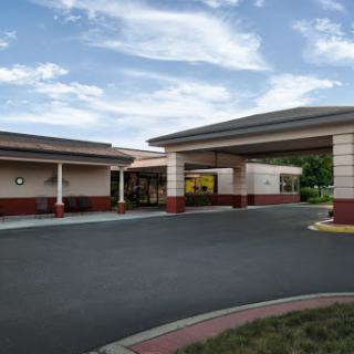 A welcoming entrance to a hospitality establishment under a bright sky.