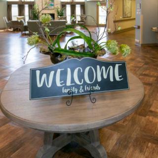 A welcoming sign on a table in a cozy lobby area.
