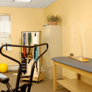 A physical therapy room equipped with exercise equipment and therapy tools.