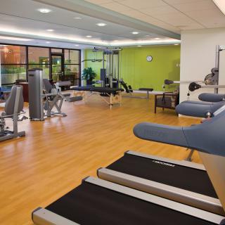 A well-equipped gym with various exercise machines and weights.