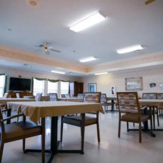 A well-lit dining area with neatly arranged tables and chairs.