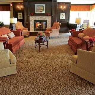 A cozy living room with sofas and armchairs arranged around a fireplace.