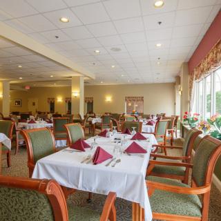 An elegantly set dining room with neatly arranged tables and chairs.
