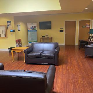 A cozy lounge area featuring black sofas and a warm, inviting atmosphere.