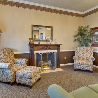 A cozy living room with patterned armchairs, a fireplace, and elegant decor.